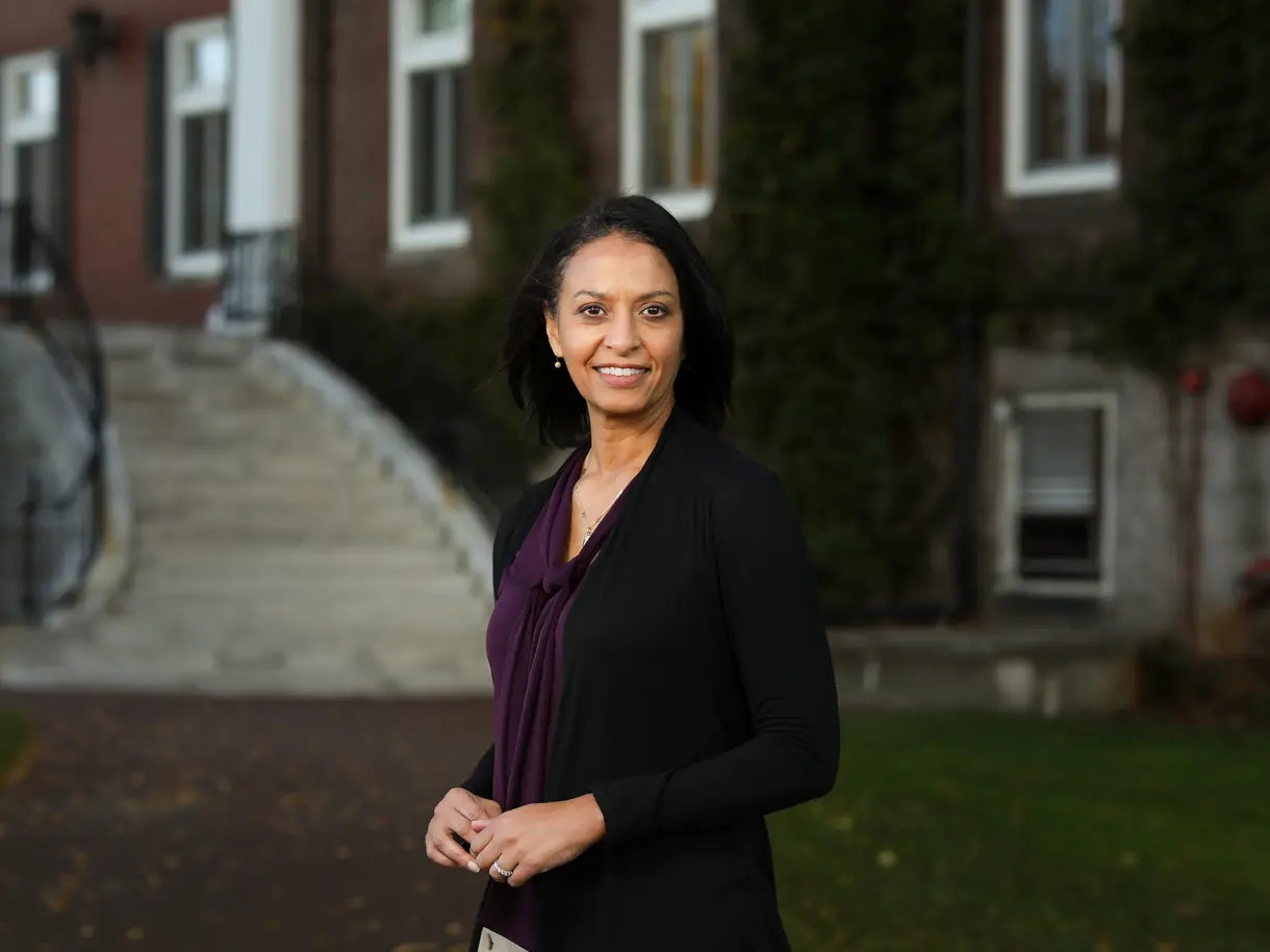 A woman standing in front of a brick building and a staircase